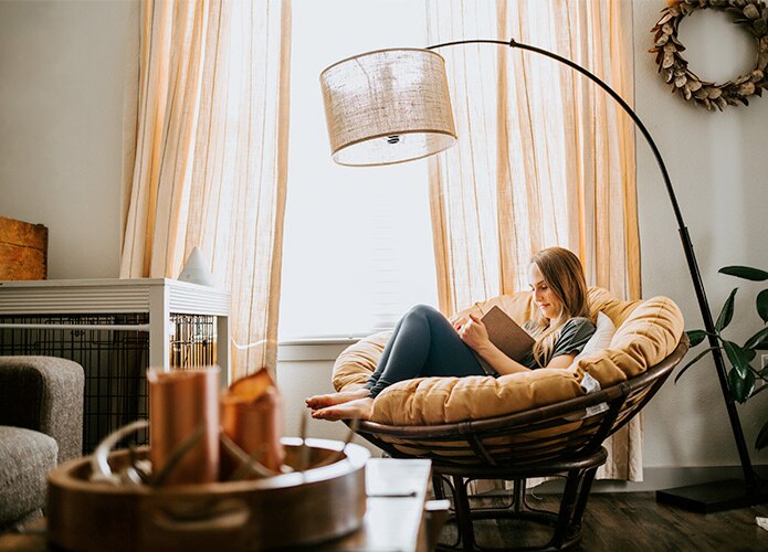 Woman reading in armchair by window