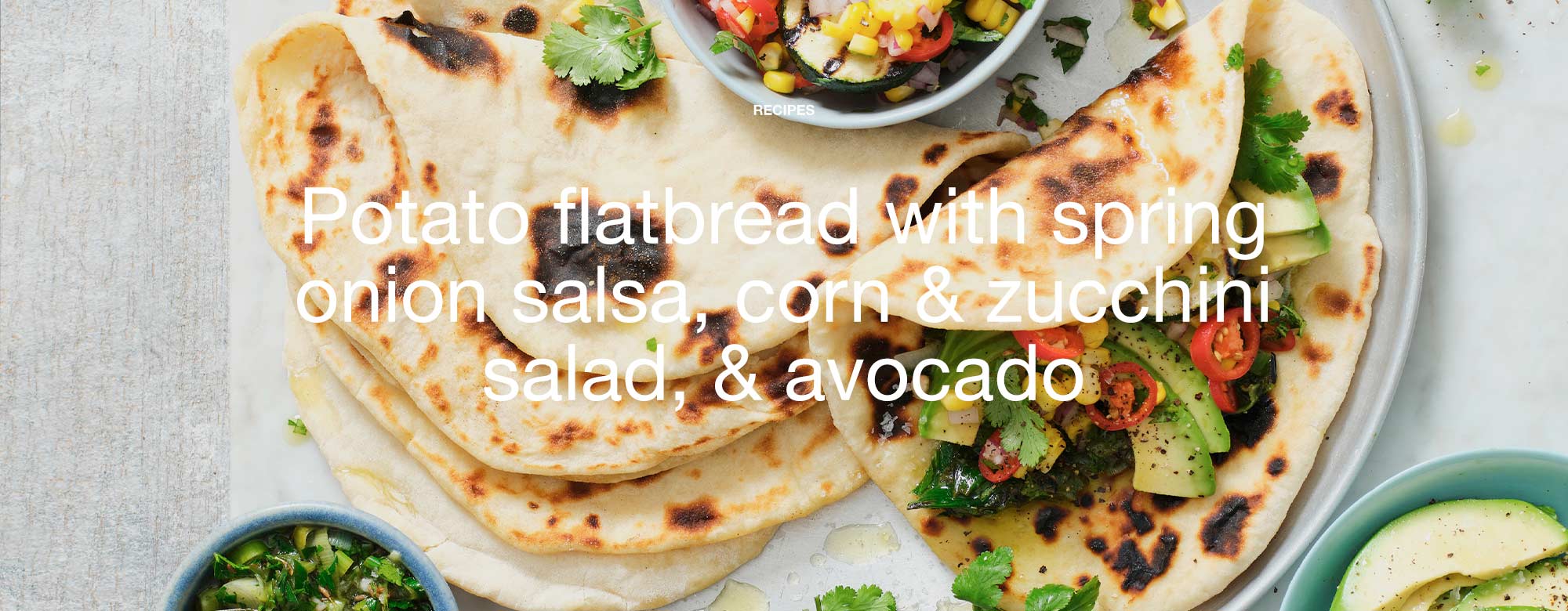 Potato flatbread with spring onion salsa, corn & zucchini salad, & avocado