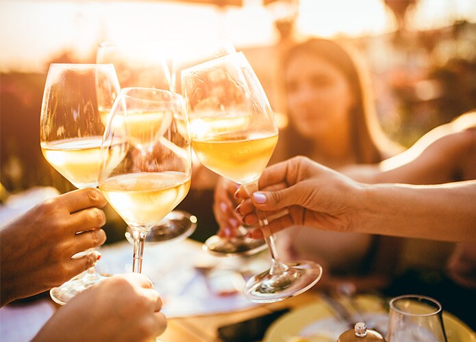 Group of people clinking glasses of white wine