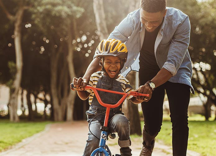 Dad teaching child to ride bike