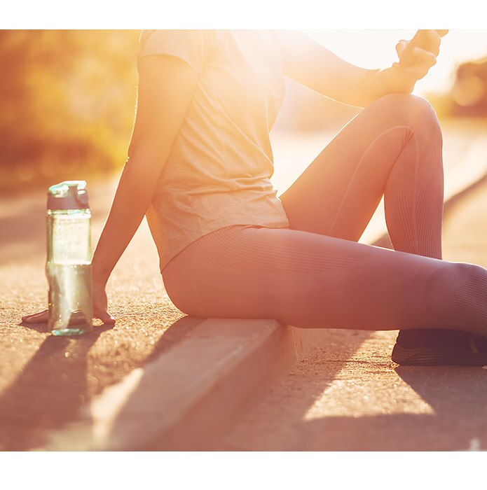 Woman resting on roadside after run