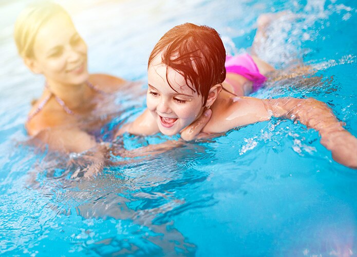 Adult teaching child to swim