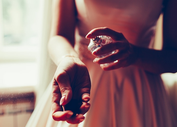 Woman spraying perfume on her wrist