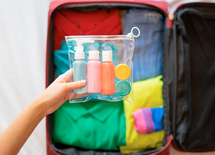 Clear toiletries bag in front of suitcase