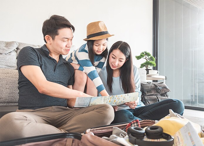 Family of three packing suitcase