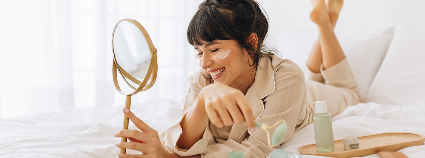 Woman doing her skincare in bed