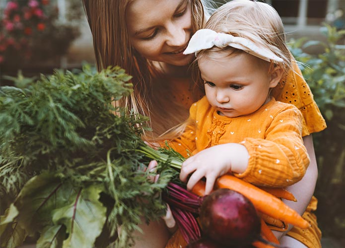 Woman and child holding vegetables